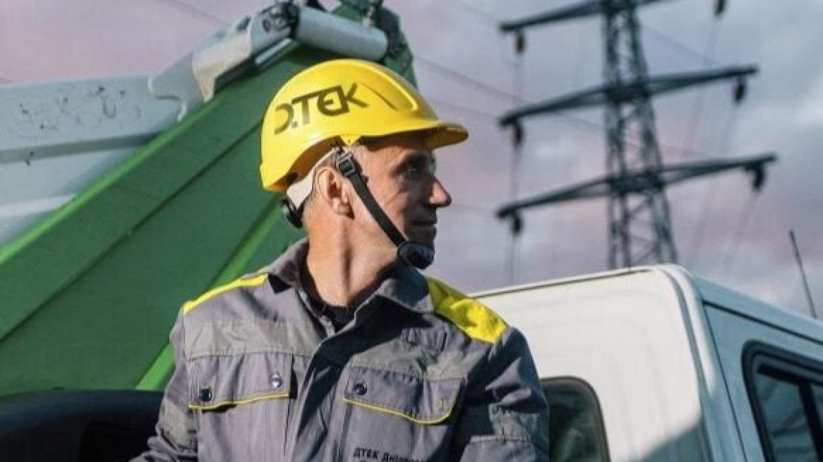 Після російської атаки на Київщині без світла залишилися понад 9,5 тисяч родин Електрик у касці з логотипом ДТЕК