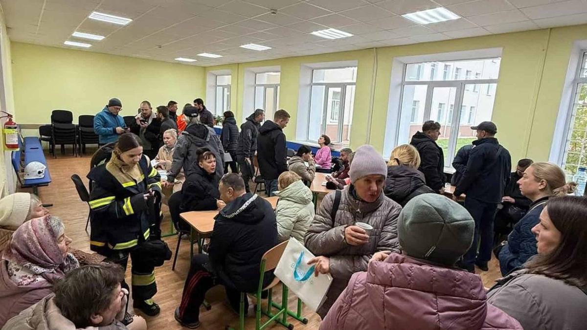 У Києві розгорнули штаби допомоги постраждалим: куди йти (оновлено) Люди в штабі допомоги після атаки РФ, більше 20 осіб у кімнаті