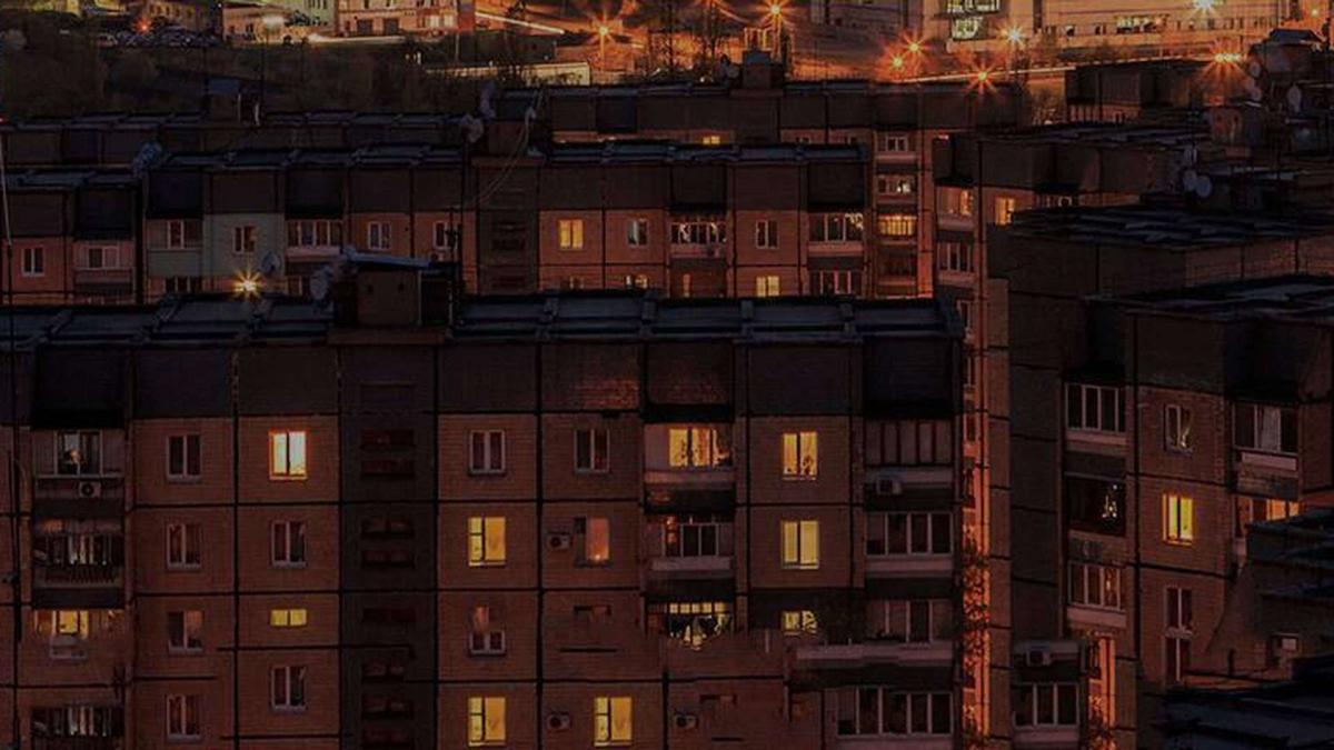 Багатоповерхівки в темноті і у вікнах горить світло