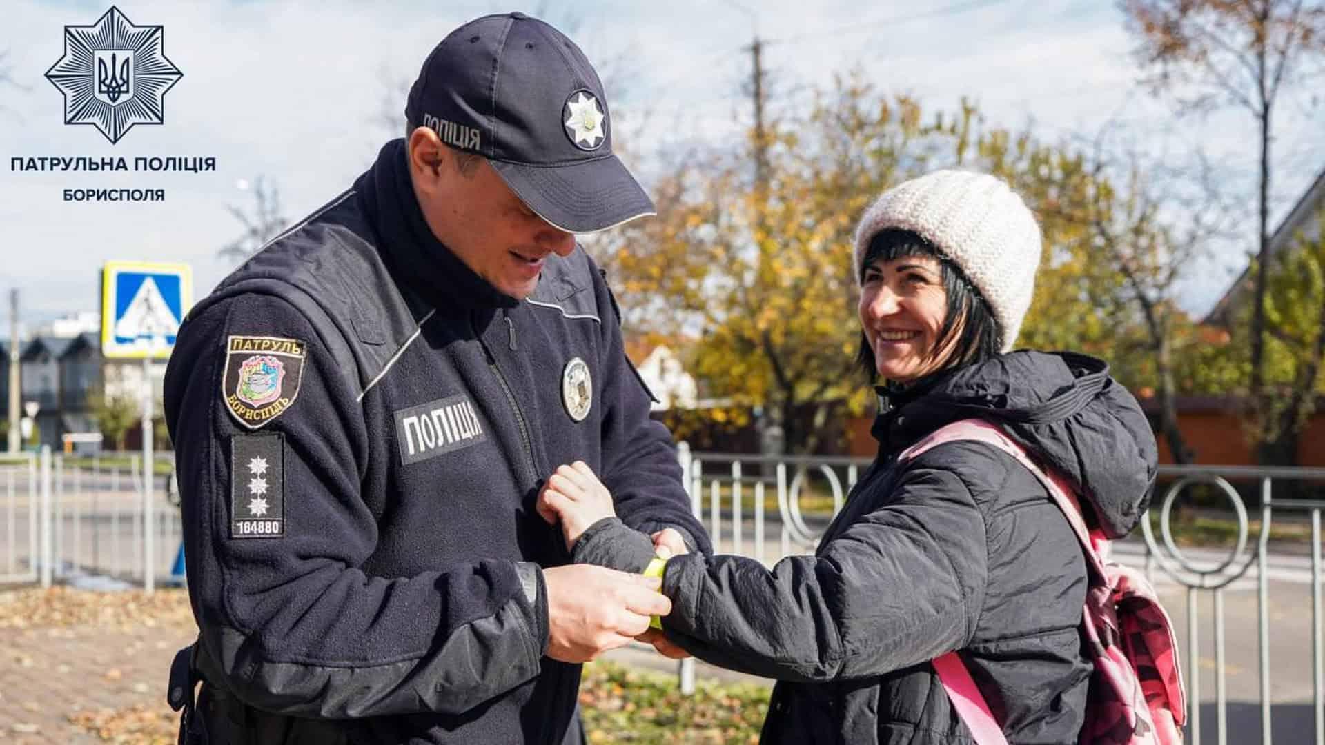 Поліцейський надіває на руку дівчині флікер, який відбиває світло в темряві