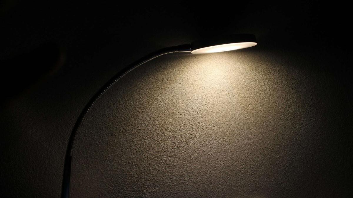 Лампа стоїть на столі і світить у повній темряві