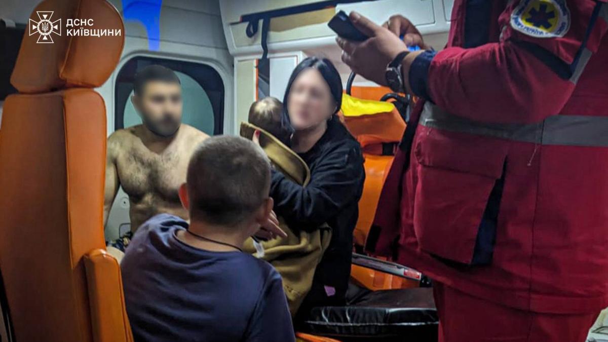 Жінка з двома дітьми і чоловіком у кареті швидкої допомоги