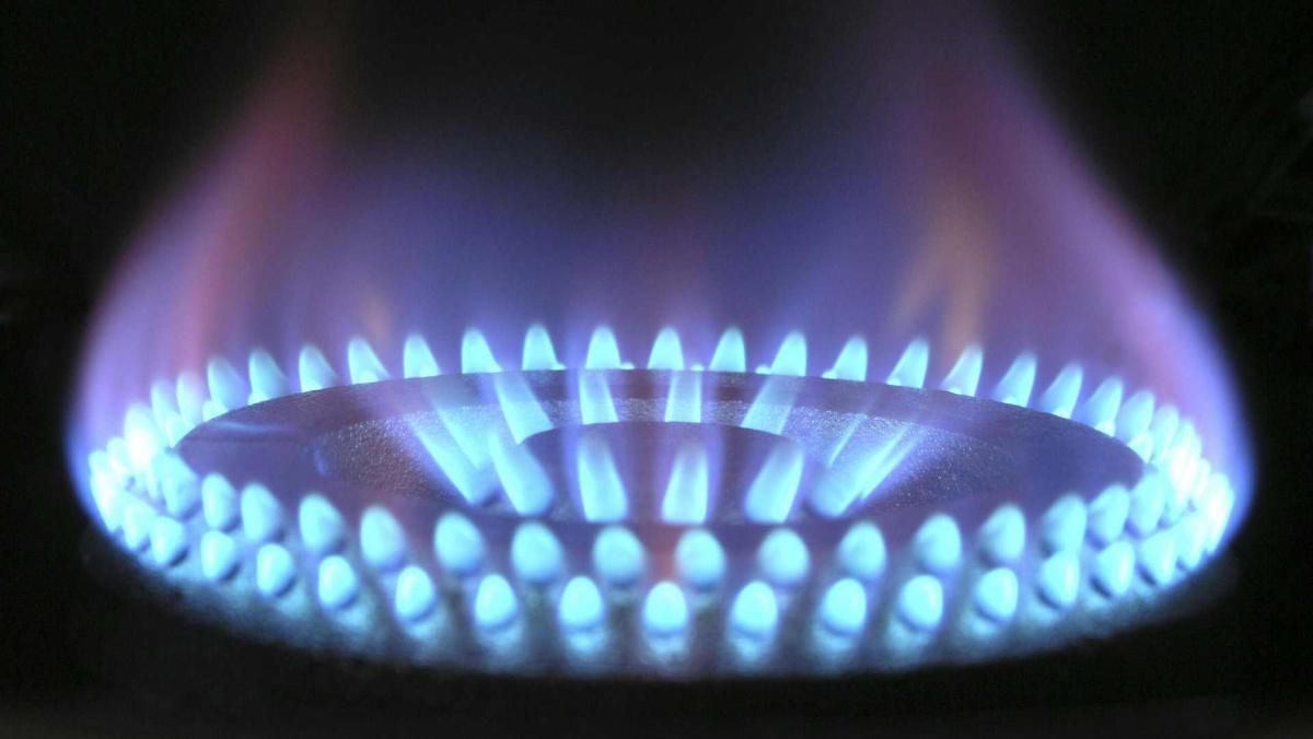 Скільки платитимемо за газ узимку: уряд назвав суму Газова плита з блакитним полум'ям, що утворює кільцеву форму на темному тлі