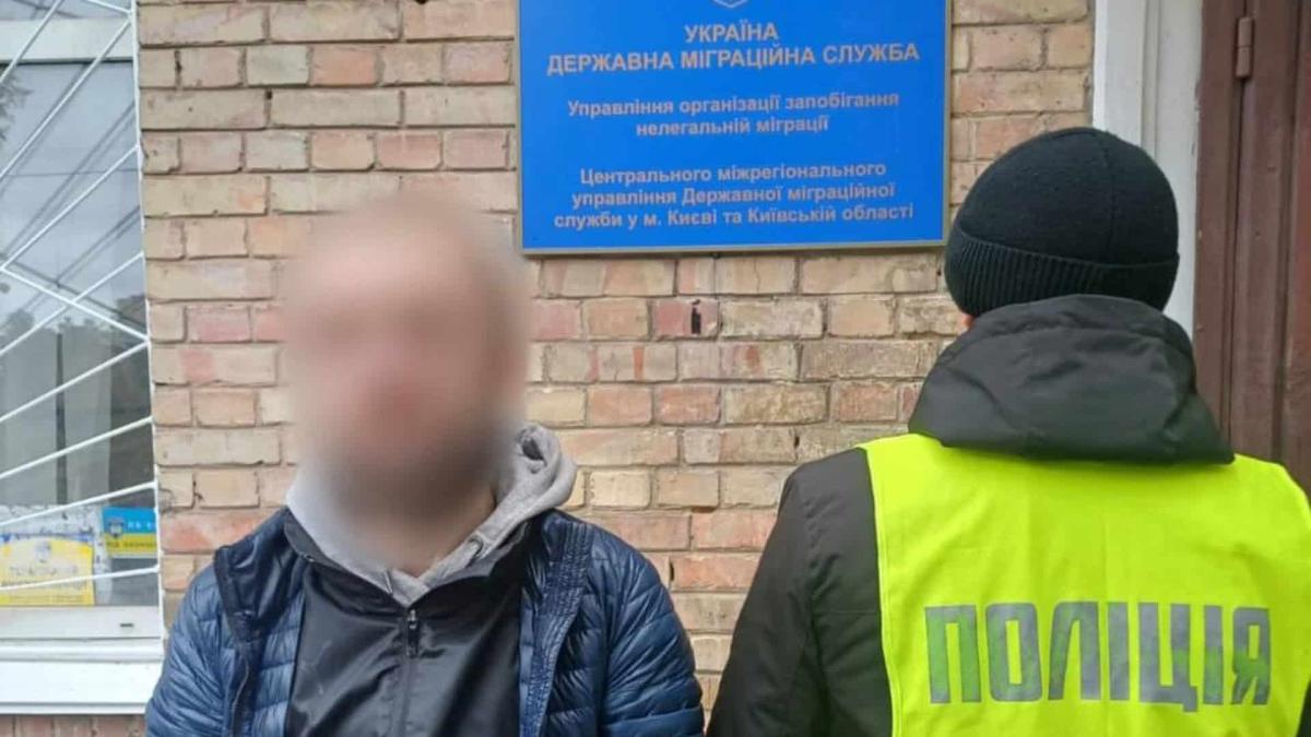 Перевірка іноземців: на Київщині оштрафували двох громадян Грузії Працівник поліції із затриманим на вулиці
