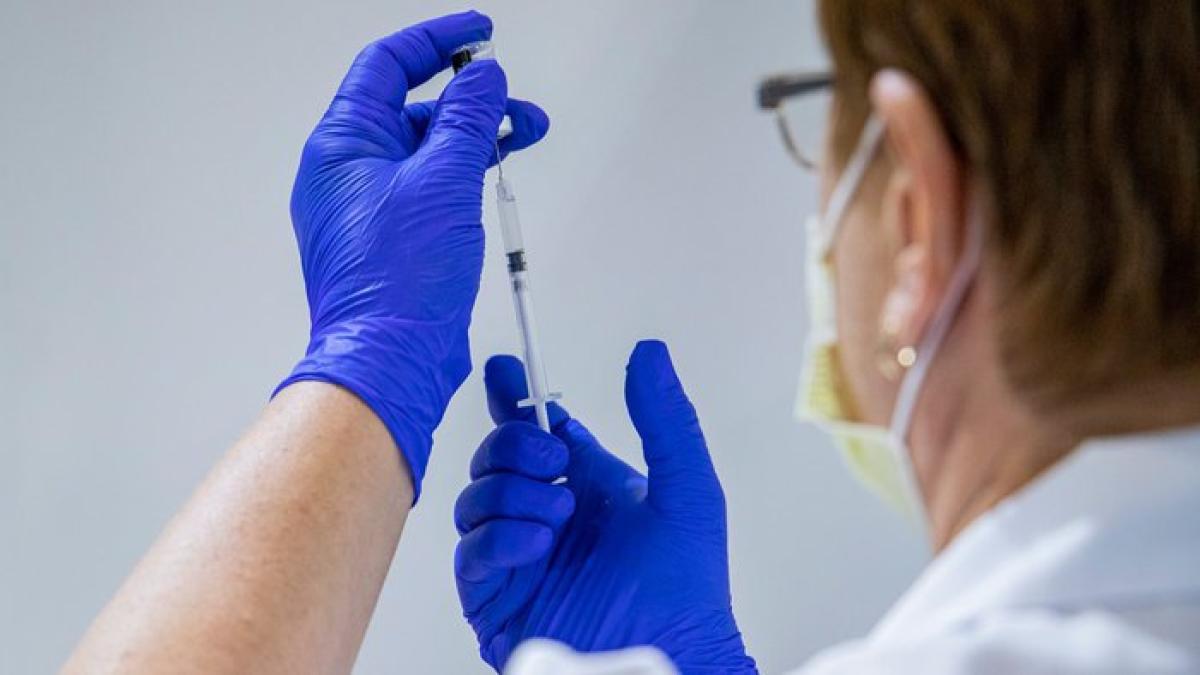 У Києві зростає кількість охочих вакцинуватися від COVID-19 — головний санлікар столиці Людина в медичній масці та рукавичках готує шприц із вакциною