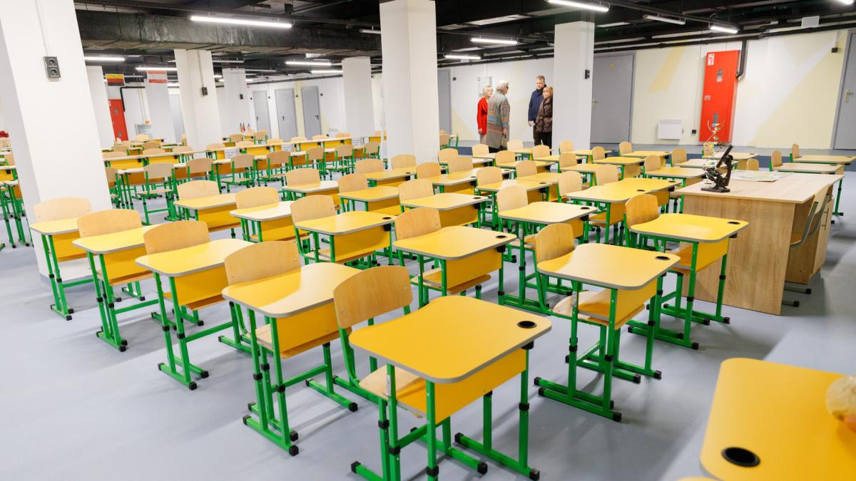 Шкільний клас з жовтими партами під землею в укритті