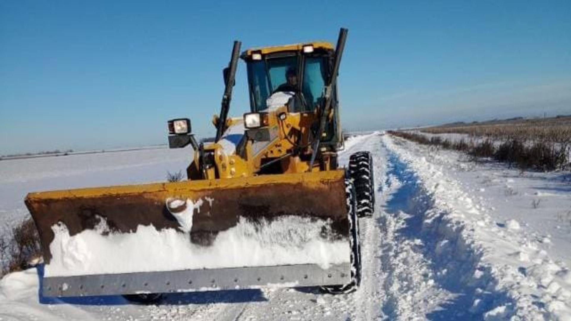 Трактор розчищає дорогу від снігу