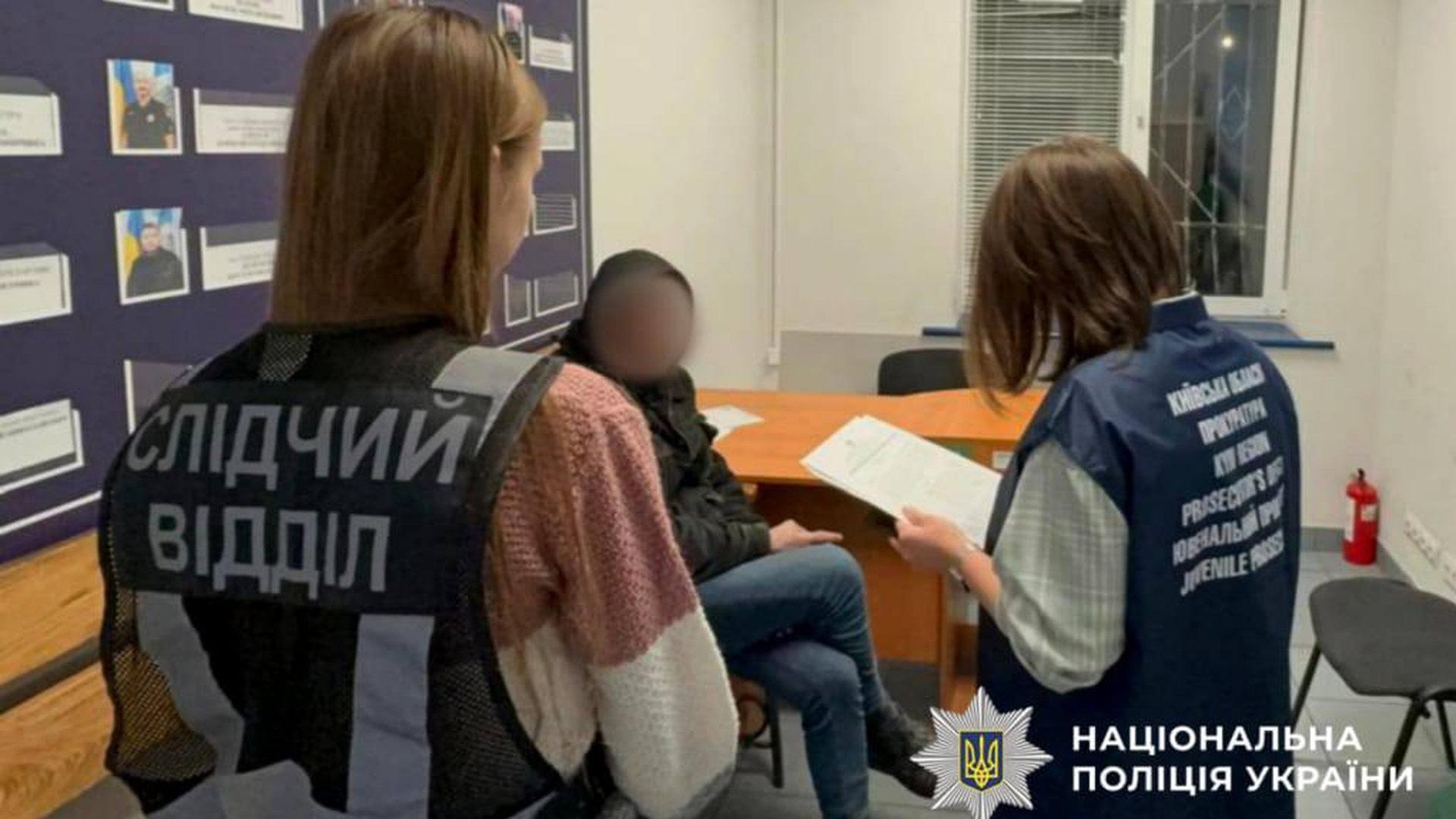 Двоє поліцейських стоять в кімнаті, з ними поруч сидить чоловік на стільці