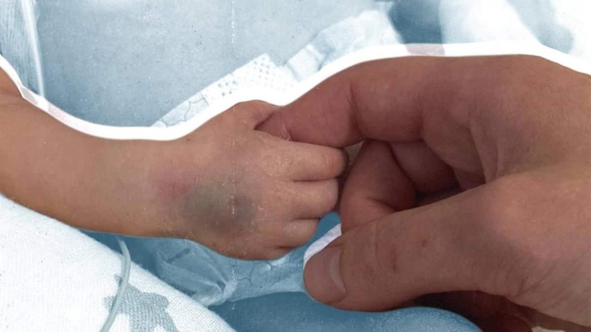 Маленька ручка дитини тримає палець тата