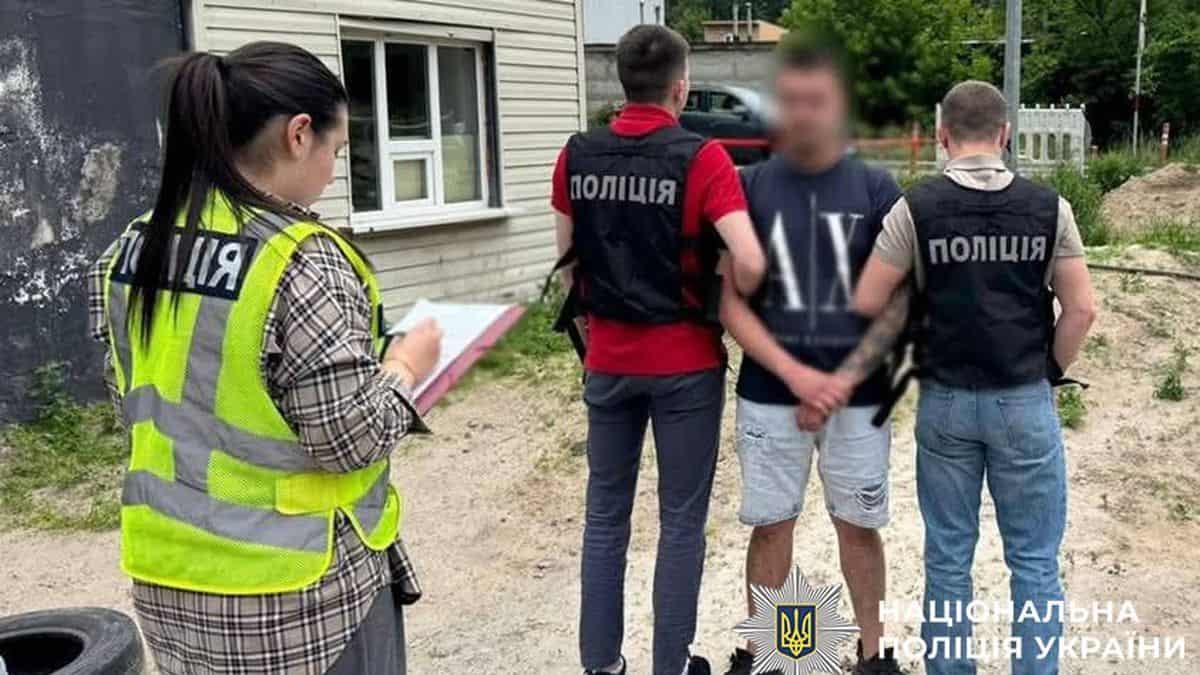 Поліцейські затримують чоловіка в чорній футболці та світлих шортах