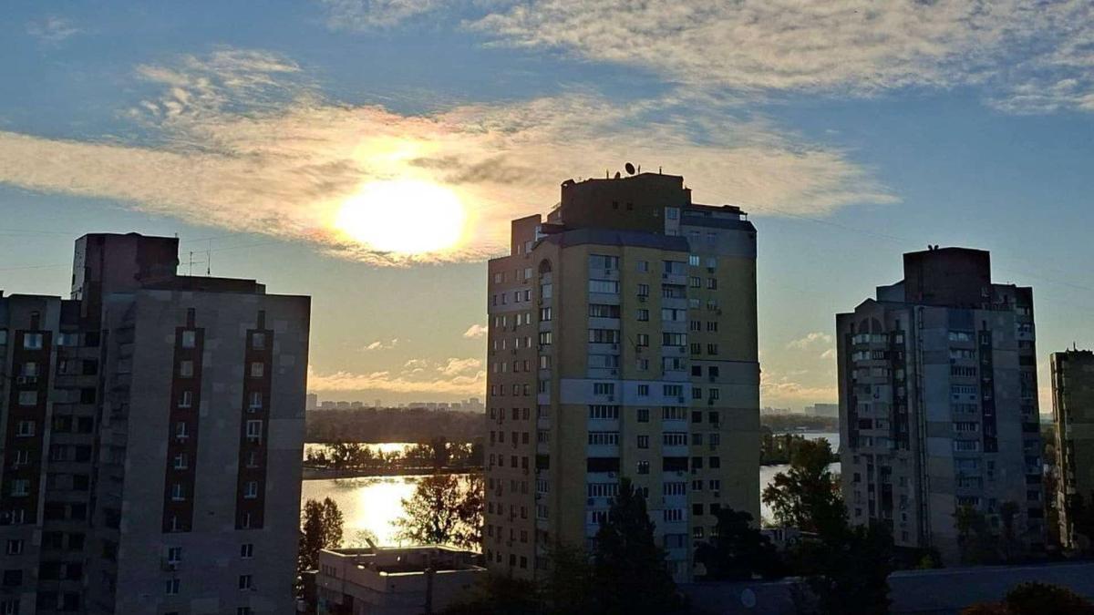 Повітря в Києві дуже чисте: якість на мінімумі забруднення Багатоповерхівки Києва зранку, на фоні них встає сонце
