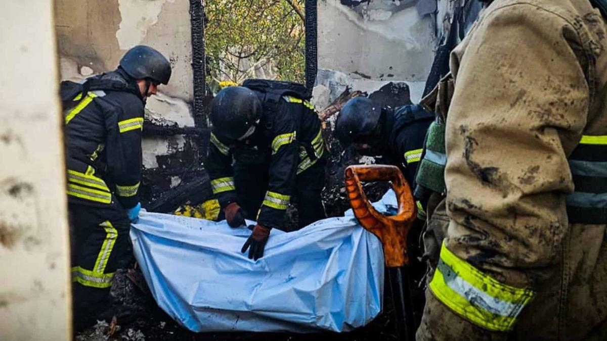 Масована атака на Київ: загинули двоє, пошкоджені будинки (оновлено) Працівники ДСНС виносять зі зруйнованого будинку тіло людини в синьому мішку