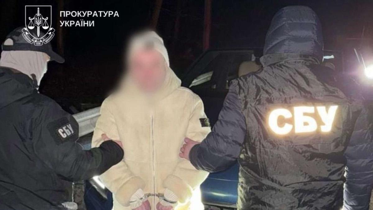 Двоє правоохоронців під руки тримають затриманого із заблюреним обличчям