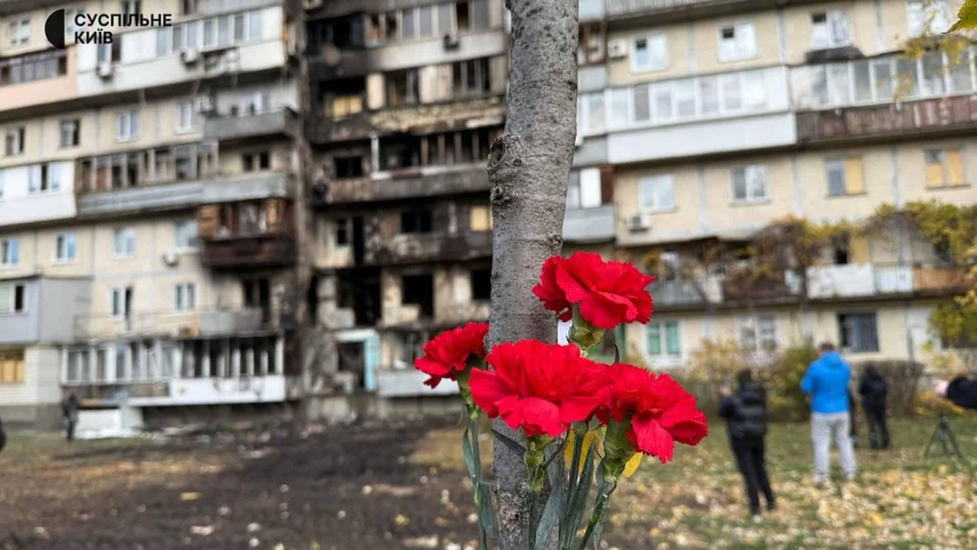 «Допоможіть закутати дитину»: перші хвилини після атаки Києва Червоні гвоздики на фоні пошкодженого житлового будинку в Києві