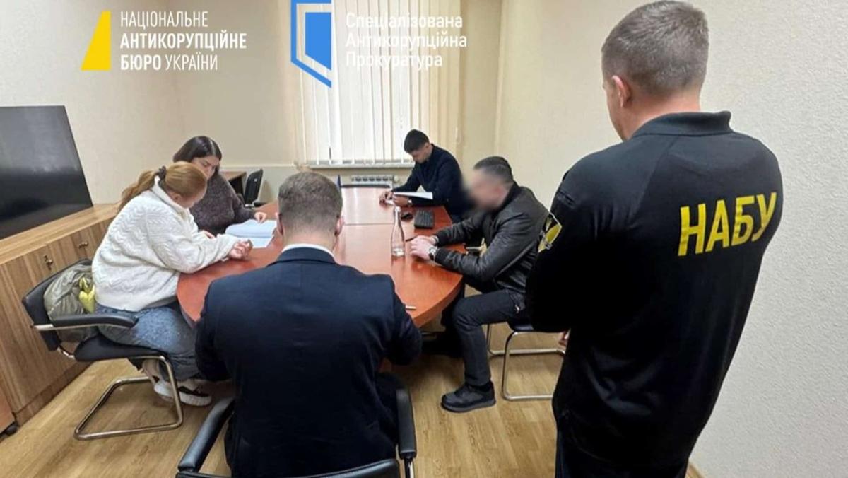Подружжя депутатів від «Слуги народу» підозрюють у приховуванні 8 мільйонів гривень Працівники НАБУ та САП проводять слідчі дії в офісі — кілька людей сидять за столом