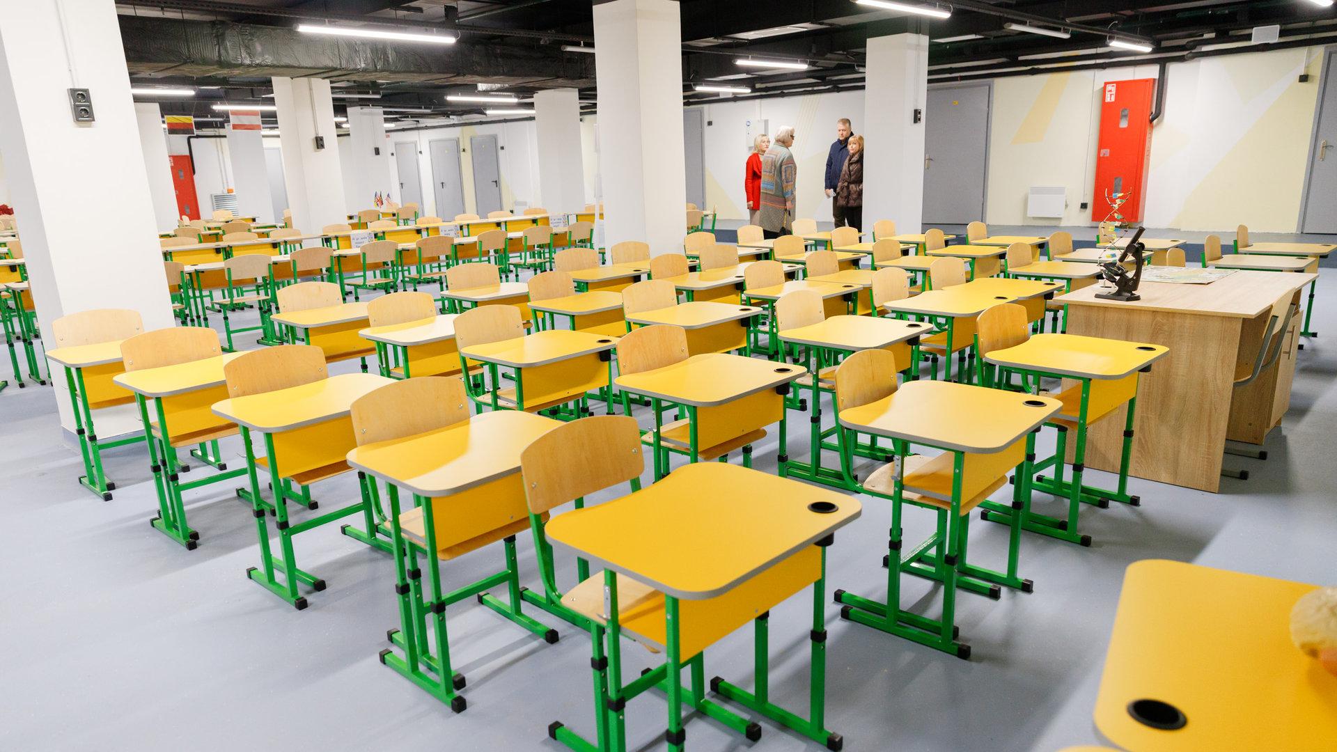 Шкільний клас з жовтими партами під землею в укритті