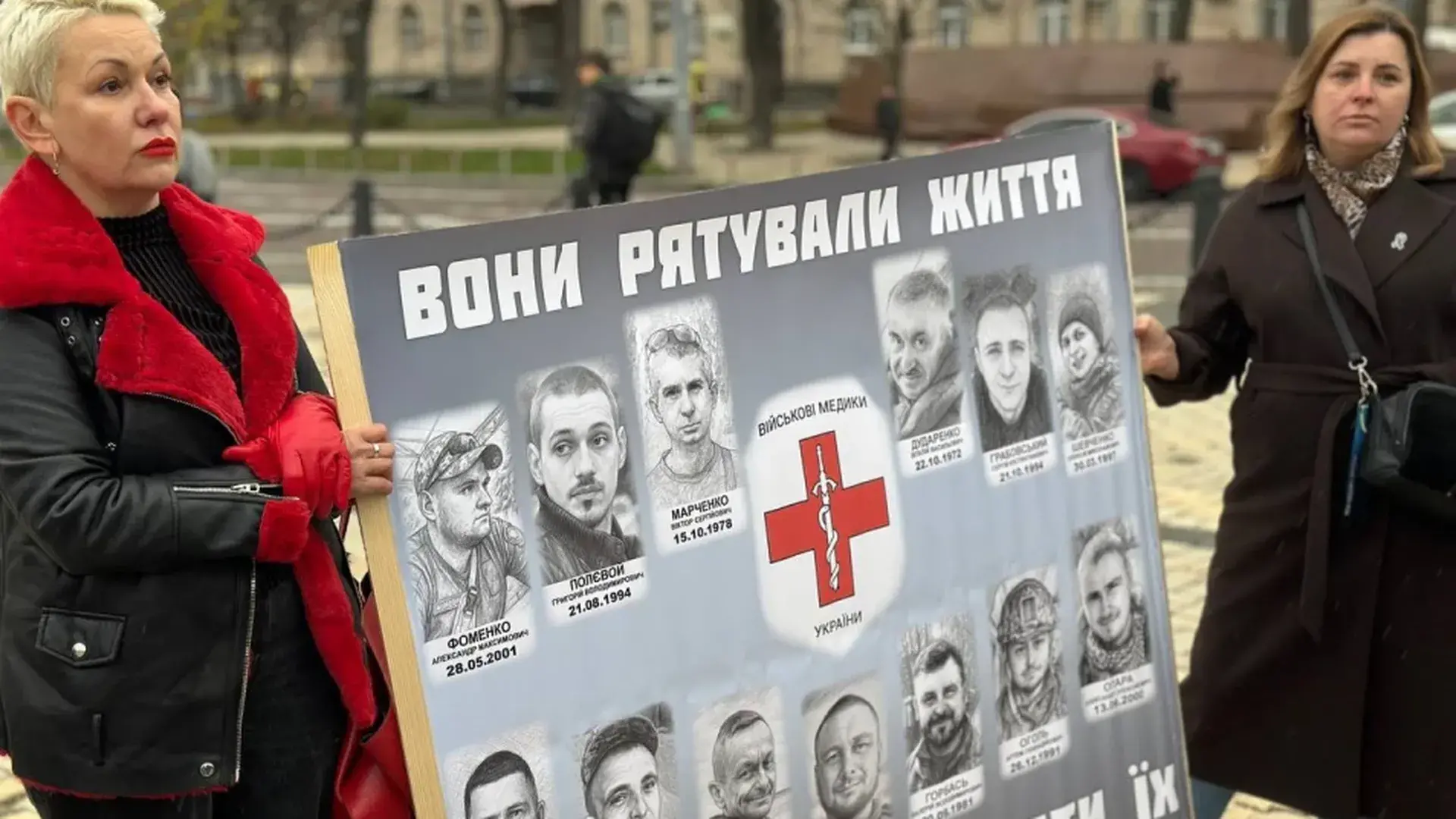 Дві жінки тримають плакат