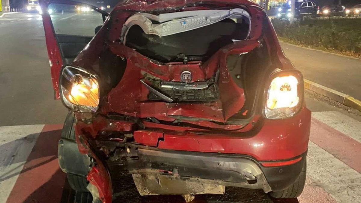 Розбитий автомобіль бордового кольору, в багажник якого врізався мотоцикл