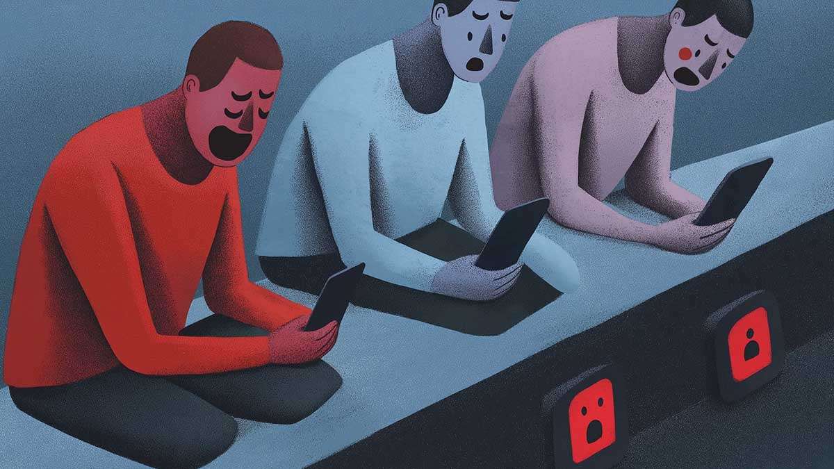 a group of people sitting at a table with their phones