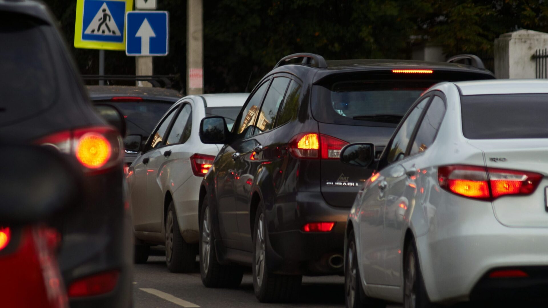 Автомобільний затор на міській дорозі з увімкненими стоп-сигналами та дорожніми знаками
