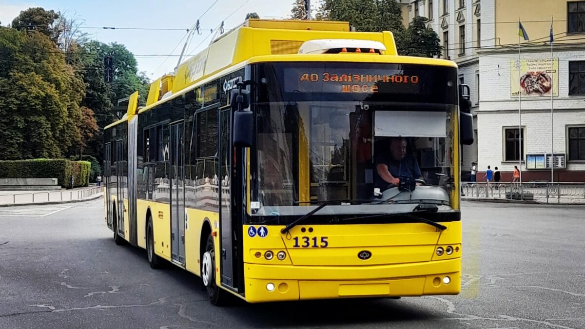 Жовтий тролейбус рухається вулицею