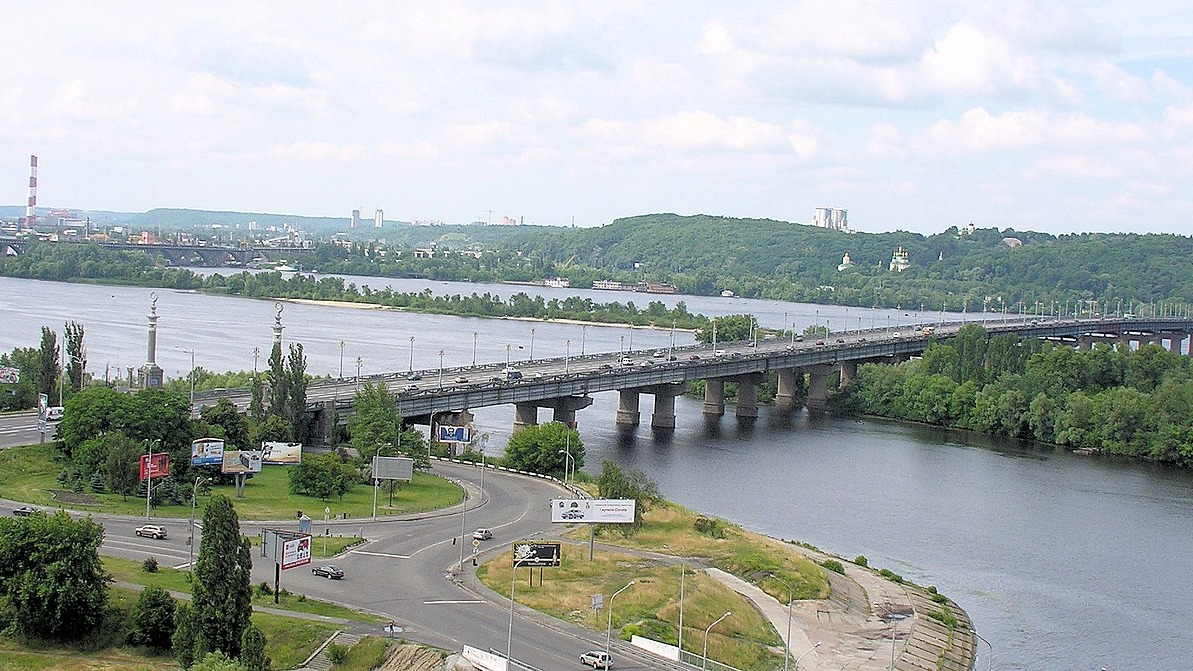 Міст, який перетинає річку, з автомобілями, що рухаються по ньому