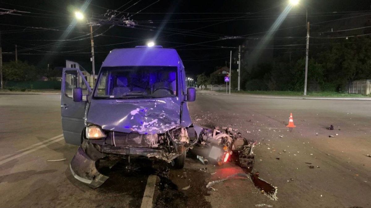 В’)їзд вантажівки в дорожню перешкоду на темній вулиці вночі, пошкоджений автомобіль, дорожні знаки та уламки на дорозі.