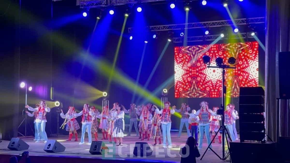 Сцена з концерту: колектив у яскравих українських костюмах виконує номер