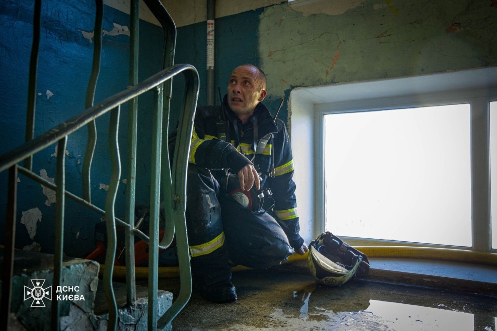 Пожежник відпочиває на сходовій клітці після роботи