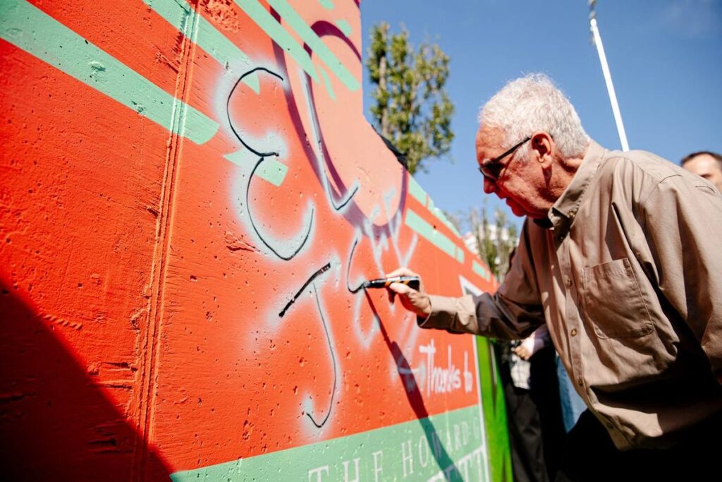 Говард Баффет залишає підпис на стіні спортивного майданчика