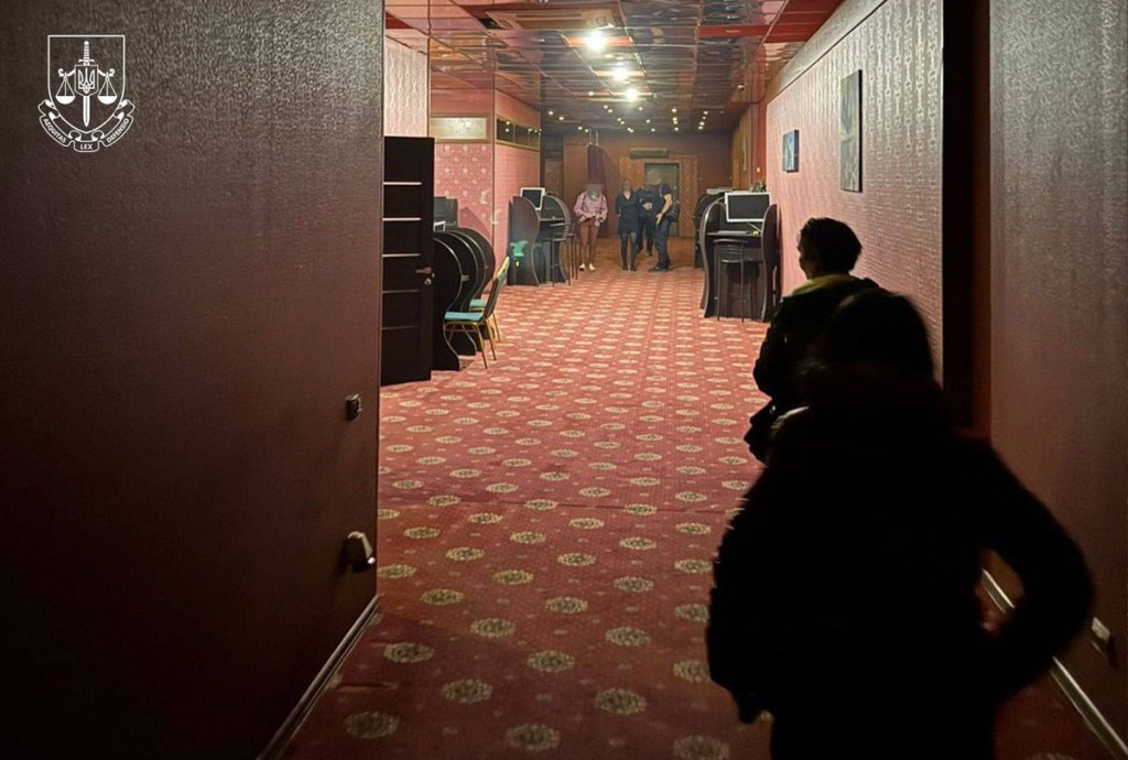 Люди у формі з написом «БЕБ» проводять перевірку в приміщенні з ігровими автоматами