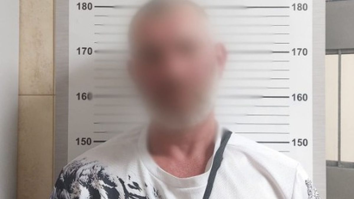 Чоловік із розмитим обличчям стоїть біля стіни