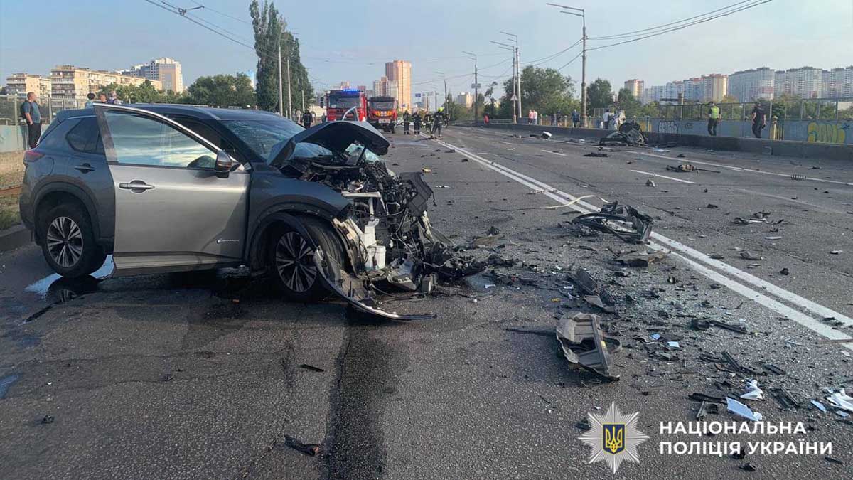 Візуал після дорожньо-транспортної пригоди на мосту у Києві: пошкоджений автомобіль, уламки та екстрені служби на місці події. Фото ілюструє серйозну аварію в столиці України.