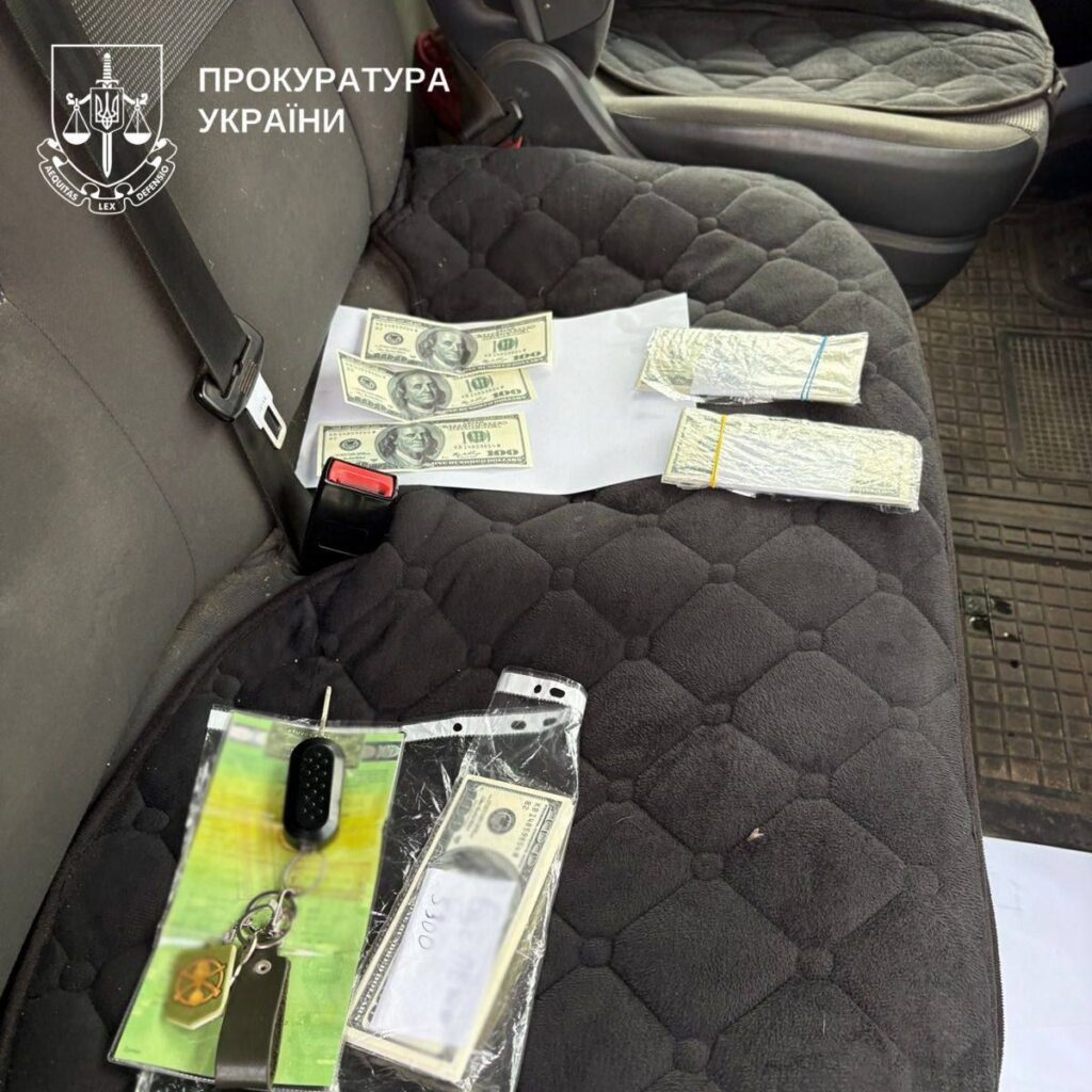 Гроші та ключі, вилучені під час обшуку, на сидінні автомобіля