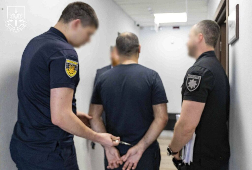 Україна спільно зі США та ЄС знешкодила угруповання кіберзлочинців Затримання чоловіка правоохоронцями у коридорі, руки в кайданках за спиною