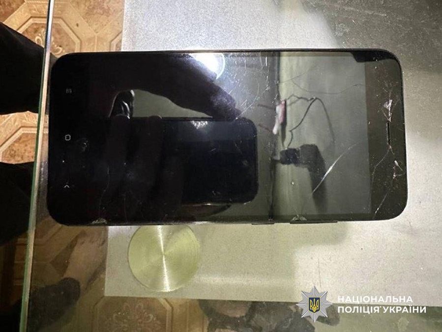 Зламаний мобільний телефон з тріщинами на екрані, ймовірно, у результаті інциденту або аварії.