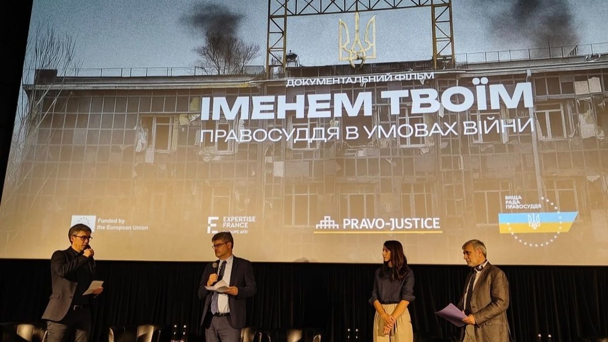Четверо людей стоять на сцені під час презентації документального фільму «Іменем твоїм: правосуддя в умовах війни»
