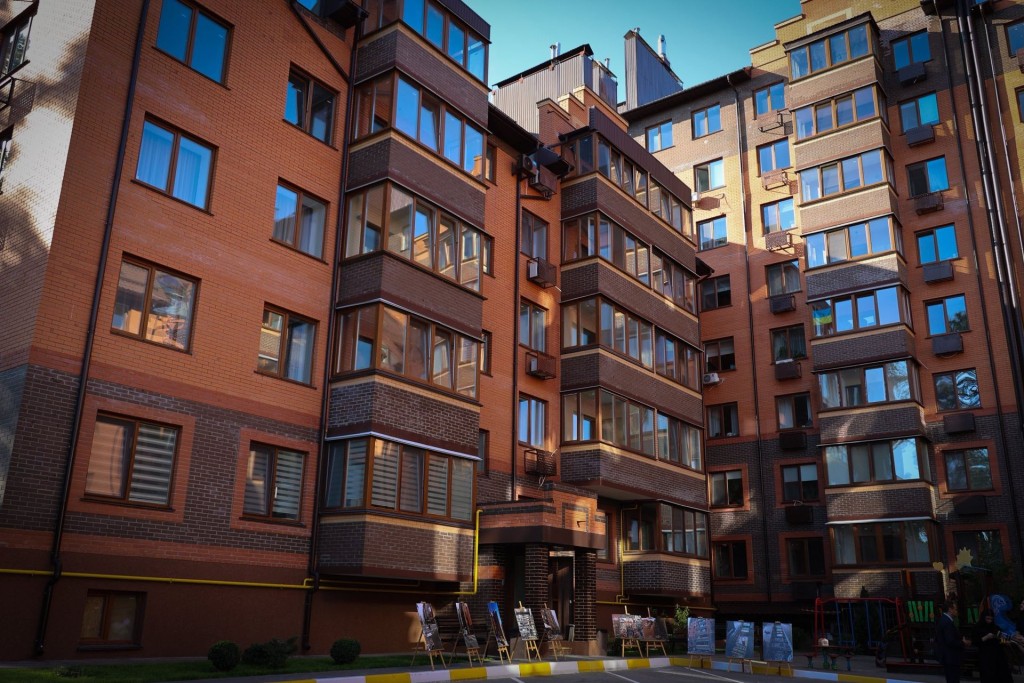 багатоповерхові цегляні будівлі з новими вікнами, відремонтованими фасадами та охайними подвір’ями