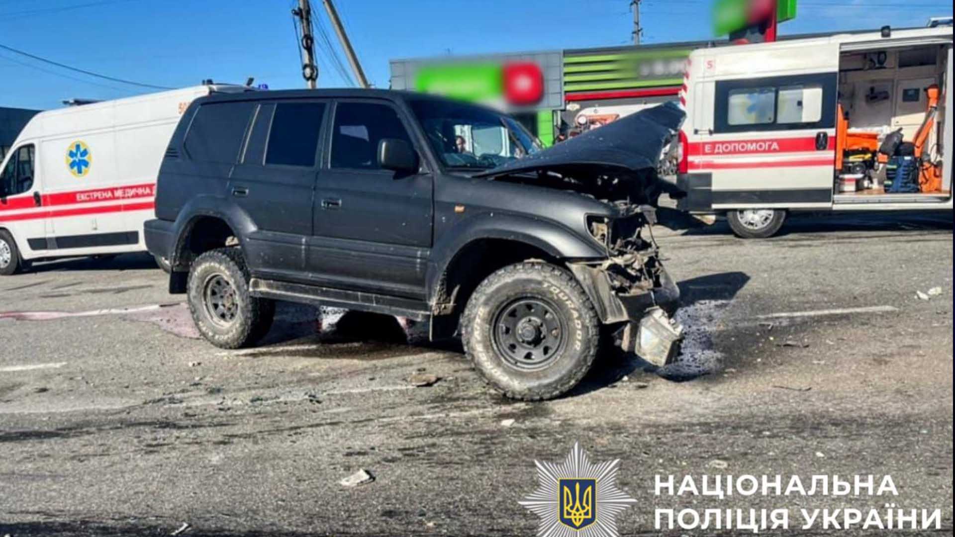 розтрощене авто посеред дороги поряд авто швидкої допомоги