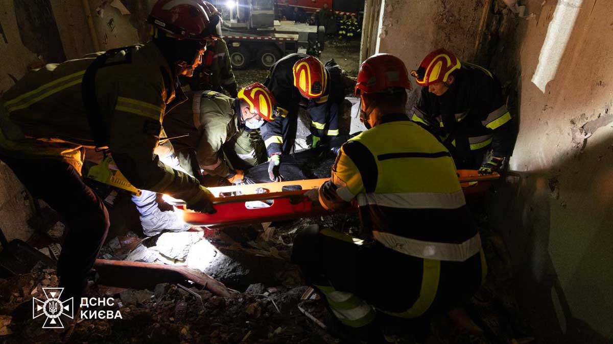 Рятувальники швидкої допомоги у Києві витягують постраждалих з пошкодженої будівлі під час аварійної ситуації.