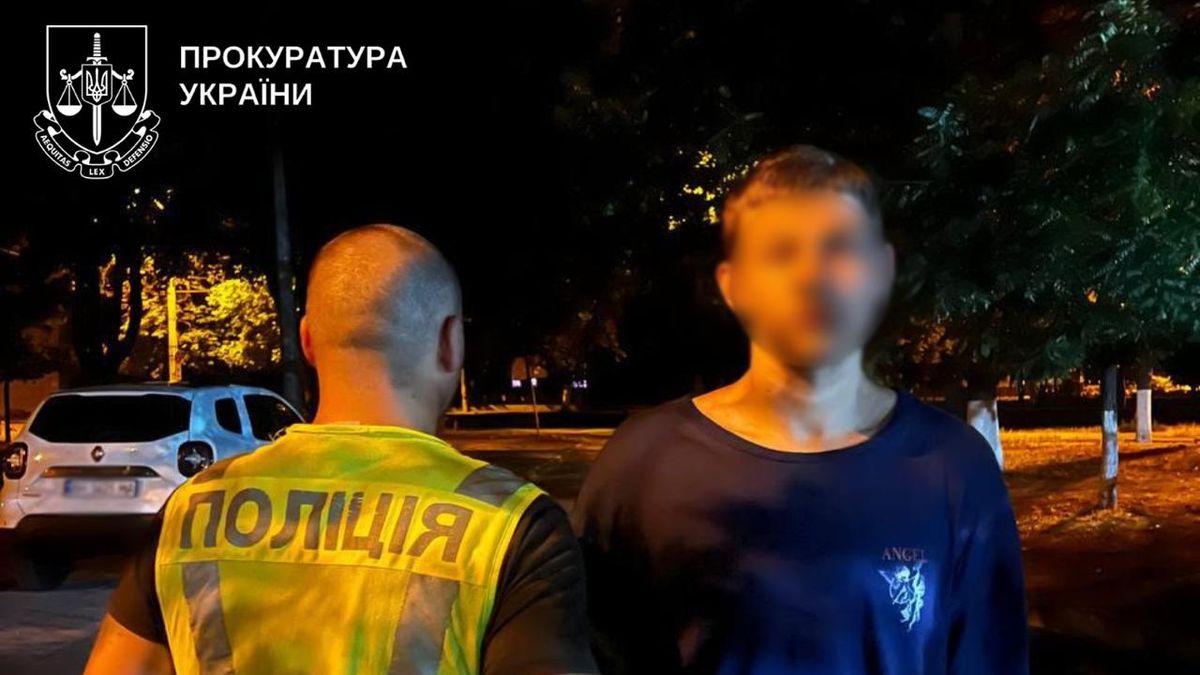 Поліцейський на вулиці Києва під час розслідування, фото ночі.