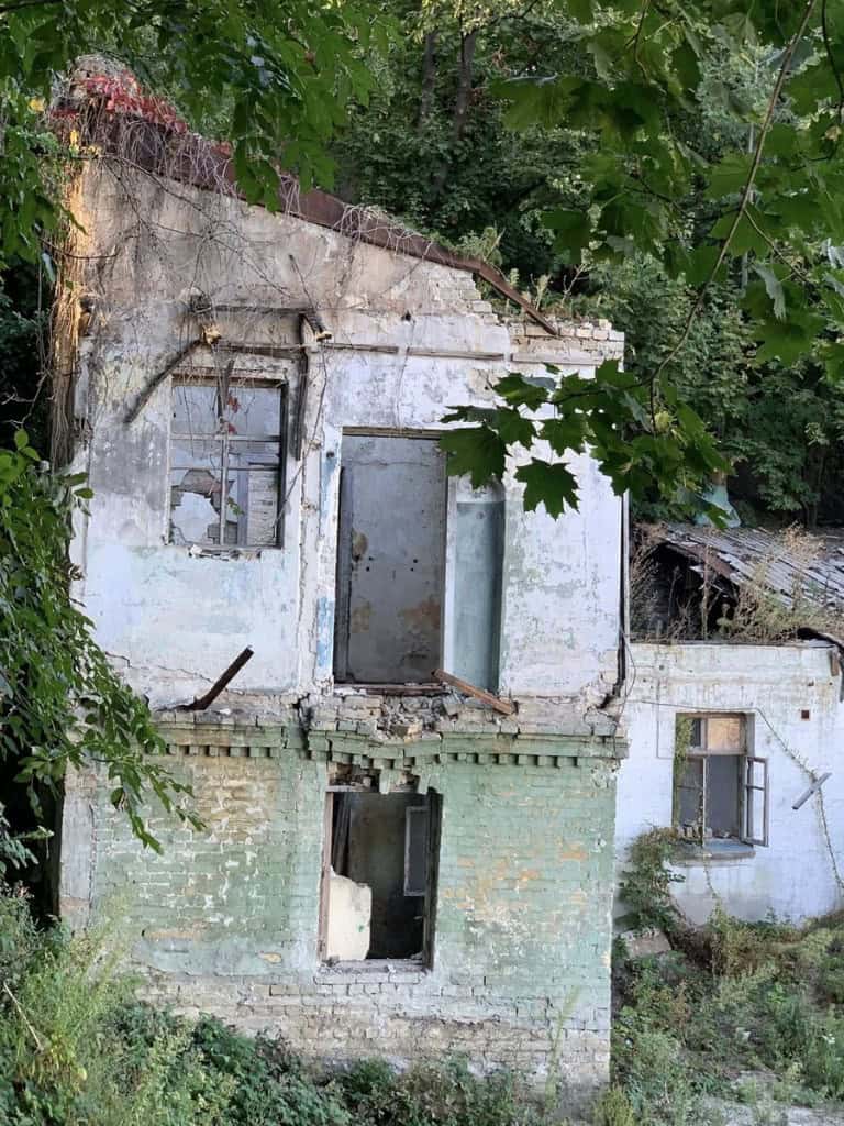 Напівзруйнований двоповерховий будинок: обвалена стіна, порожні дверні та віконні прорізи