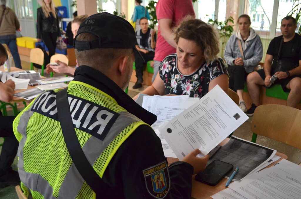 Розпитування поліціянта з громадянкою під час громадської зустрічі в Києві.