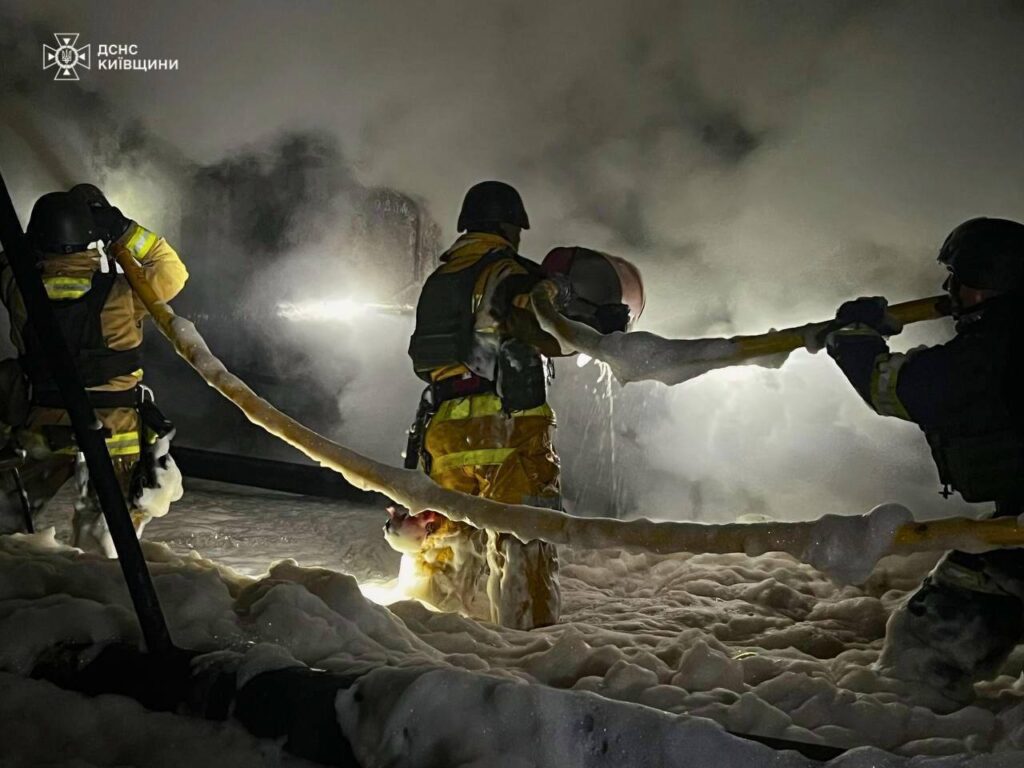 Пожежні вогнеборці гасить пожежу у засніженій будівлі в Києві, залучена техніка та застосовуються спецзасоби для боротьби з вогнем у складних умовах зимового сезону.