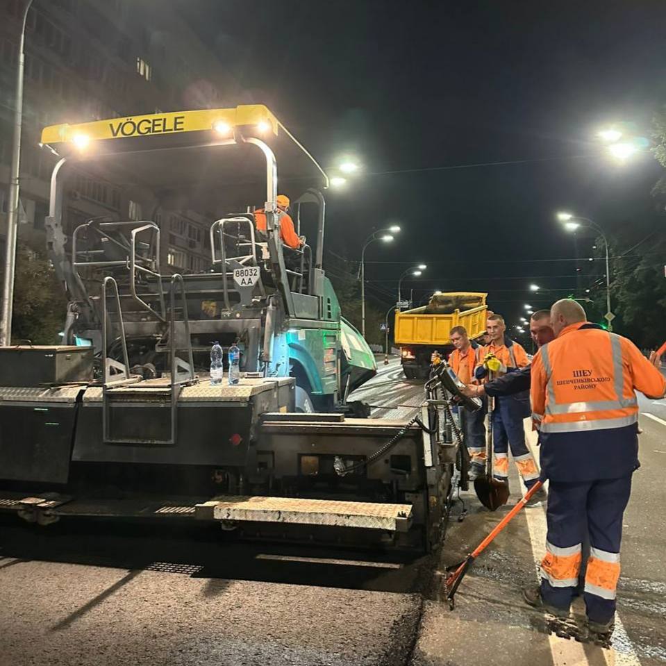 Нічні роботи дорожників з укладання асфальту за допомогою техніки