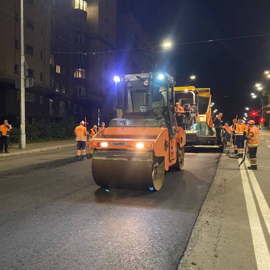 Нічні роботи дорожників з укладання асфальту за допомогою техніки