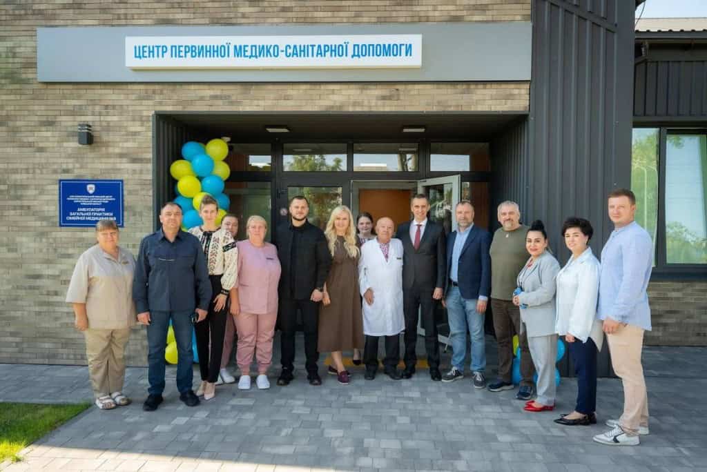 Бориспільщина: у Рогозові відкрили нову амбулаторію сімейної медицини Група медичних працівників та посадовців позує біля входу до Центру первинної медико-санітарної допомоги, прикрашеного синьо-жовтими кулями