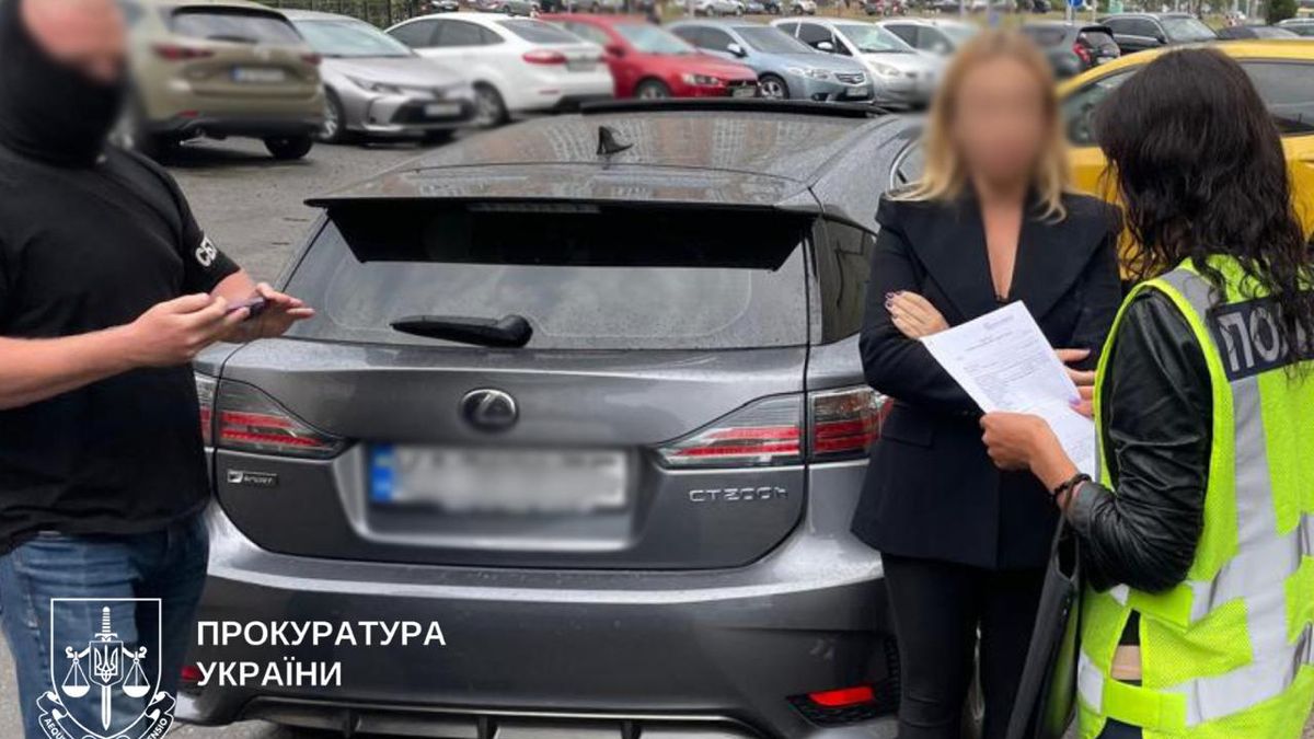 Майстер-поліціянт та дорожній інспектор обговорюють документи біля автомобіля в Києві.