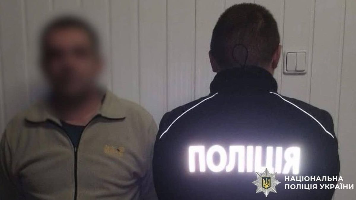 Затриманий чоловік стоїть поруч із поліцейським