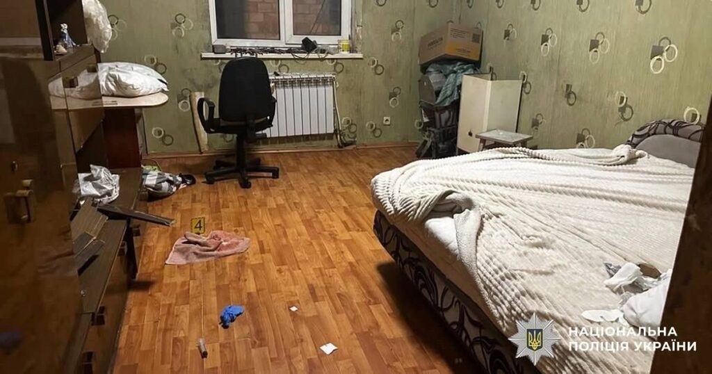 Кімната квартири з розкиданими речами та слідчими мітками після події